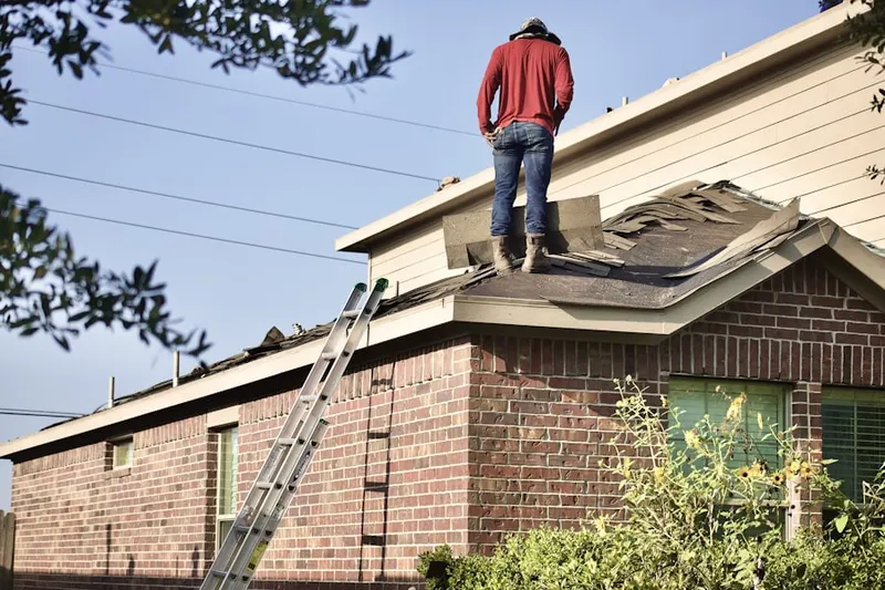 Professional roofer working on a residential roof in Constant Friendship